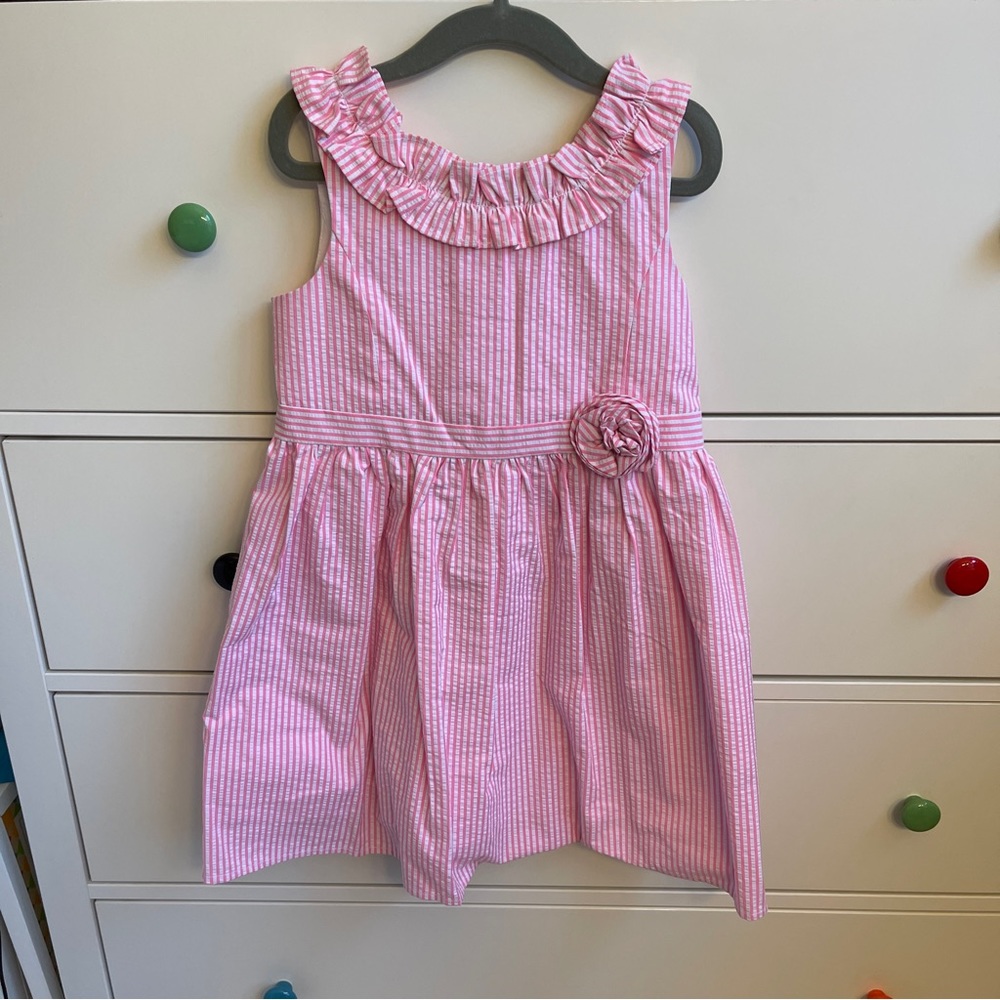 Lilly Pulitzer pink and white seersucker dress with ruffles and rosette.